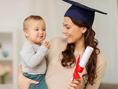 a young woman with a graduation cap on holding a baby