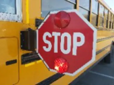 the side of a school bus with its stop sign out